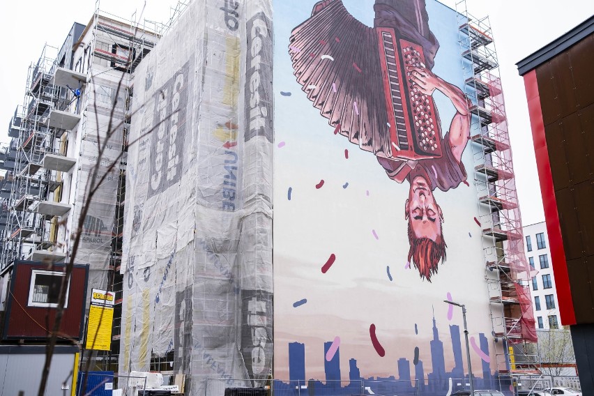 Nowy mural w Warszawie. Uliczny grajek do góry nogami