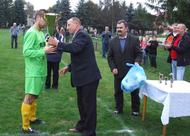 Prezes chrzanowskiego podokręgu piłkarskiego Józef Cichoń wręcza główne trofeum za wygranie rywalizacji o Puchar Polski kapitanowi MKS Trzebinia Siersza Tomaszowi Szczepanikowi w finale z Nadwiślaninem, rozegranym w Gromcu.