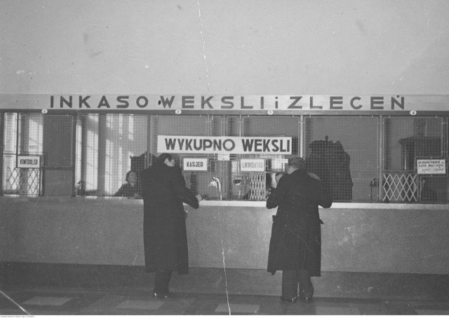 Interesanci przed okienkami pocztowymi na Poczcie Głównej w Krakowie.