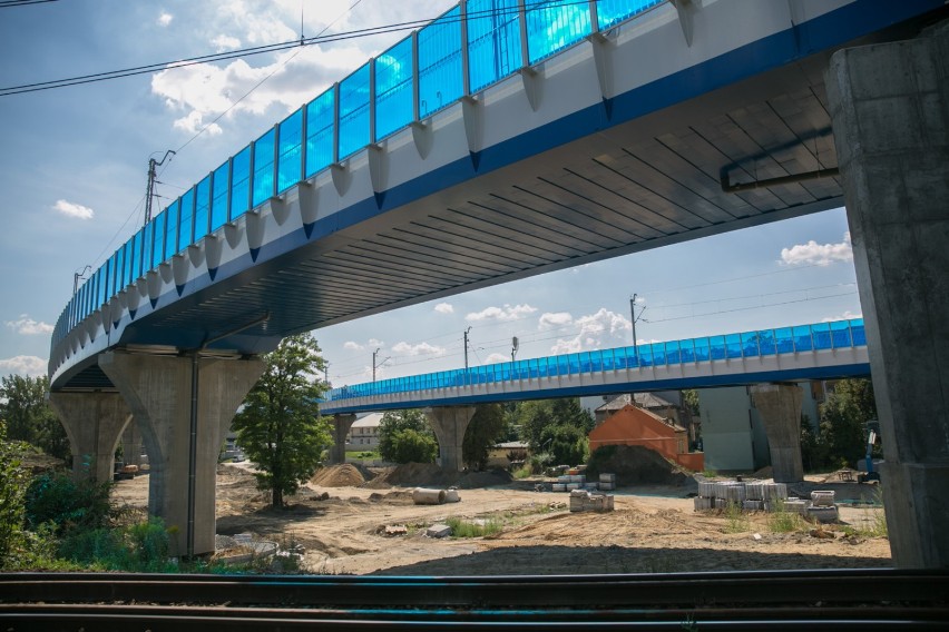 Niebieskie ekrany akustyczne wzdłuż estakady kolejowej są...