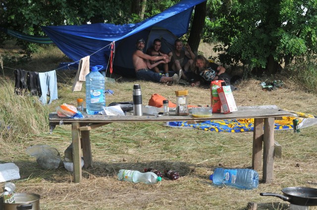 Przyjechali z Sopotu, chociaż pochodzą z różnych rejonów Polski. Świrus, Czekolada i Kapłan to trzej pierwsi tegoroczni woodstockowicze. Do Kostrzyna przyjechali przed tygodniem. Założyli obóz w lesie przed sceną.


-&nbsp;Po przyjeździe pierwsze kroki skierowałem do Dziadka - mówi Świrus. W lesie przed sceną jest pamiątkowy kamień, poświęcony Stanisławowi Kuleszyńskiemu, który przez woodstockowiczów nazywany był właśnie Dziadkiem.   Dziadek zmarł w 2013 r. po długiej walce z chorobą.  Wcześniej przez lata był jednym z pierwszych i jednym z najstarszych woodstockowiczów. Zawsze rozbijał swój obóz tu, gdzie stoi poświęcony mu kamień. Tutaj też swój obóz założyli Świrus, Czekolada i Kapłan. - Ale później się stąd wyniesiemy. Stoi tu kontener na śmieci, jest buda z papierosami i za dużo ludzi - mówi Świrus. Naszej rozmowie przysłuchuje się jeszcze dwóch woodstockowych weteranów. Razem spędzają czas, rozmawiają, bawią się.

Wszystkie informacje o Przystanku Woodstock 2017 w Kostrzynie nad Odrą:  Przystanek Woodstock 2017: koncerty, zdjęcia, filmy, informacje

Dlaczego przyjechali tak wcześnie? - Bo tylko w ten sposób można poczuć klimat Woodstocku. Poznajemy ludzi, spotykamy się ze znajomymi i widzimy, jak powstaje cała woodstockowa infrastruktura - mówią „pierwsi”. - Przychodził do nas lis, sarny. Teraz jest już za głośno, więc zwierzaki nas nie odwiedzają - mówi Świrus.

Do Kostrzyna przyjechali przed tygodniem. Są na polu, na którym nie ma jeszcze kompletnie żadnej infrastruktury. Nie ma prądu, toalet, wody, a do najbliższego sklepu jest około dwóch kilometrów. - Pomagają nam mieszkańcy. Poza tym niemal codziennie chodzimy do miasta po zakupy - mówią pierwsi woodstockowicze. Dodają, że zagląda do nich policja. - Spisali nas, dostaliśmy nawet dwa mandaty za picie alkoholu w miejscu publicznym. Ale też pytają, czy wszystko dobrze, czy jesteśmy bezpieczni - mówią.

Zobacz dziewczyny Przystanku Woodstock Woodstock 2016: Dziewczyny, które wpadły nam w oko trzeciego dnia festiwalu [ZDJĘCIA]

Wśród pierwszych woodstockowiczów jest też Woodstock. To kundelek, który przybłąkał się do nich kilka dni temu. - Widać, że jest smutny, ktoś albo go porzucił, albo bardzo skrzywdził. Ma zranioną tylną łapę, opiekujemy się nim. Zrywa się na równe nogi, gdy tylko podjeżdża samochód, albo ktoś nas odwiedza - mówi Świrus. 

Przystanek Woodstock 2017 rozpocznie się 3 sierpnia (w czwartek) i potrwa do soboty, 5 sierpnia. Będzie to już 23. edycja tej imprezy. 

Chcesz wiedzieć kto zagra na Przystanku Woodstock 2017? Przystanek Woodstock 2016: zespoły, koncerty kto zagra

