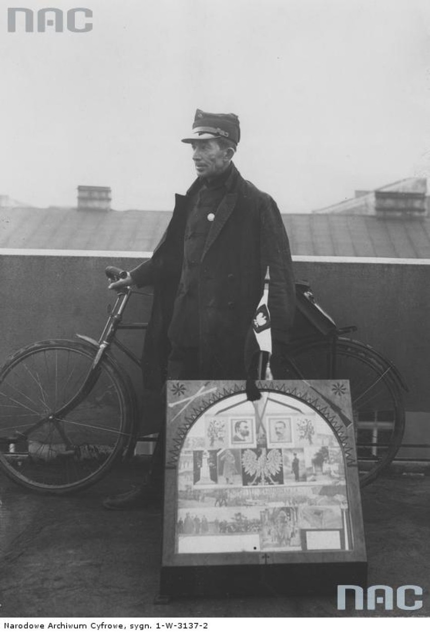 Jan Kosik z rowerem na dachu Pałacu Prasy w Krakowie. Obok widoczna tablica pamiątkowa