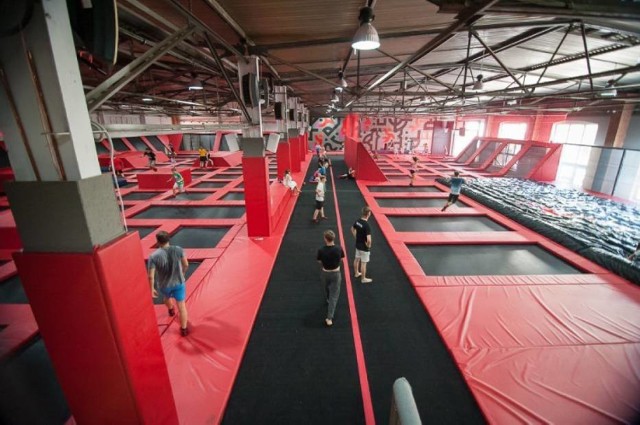 Hangar 646 to chyba najpopularniejszy park trampolin w Warszawie. Jest to miejsce, które łączy w sobie dobrą zabawę i sport. 
Pierwszy Hangar 646 o powierzchni 2700 m2 powstał na Gocławiu w 2015 roku, a dokładnie przy Wale Miedzeszyńskim 646. Znajduje się tam ponad 60 trampolin różnego rodzaju i o różnym stopniu wybicia, jak również 6 trampolin sportowych. Na miejscu można też zagrać w koszykówkę, spróbować skoków do wypełnionego miękkimi gąbkami basenu, skorzystać z planszy akrobatycznej i 12-metrowej rampy dla snowboardzistów, rolkarzy, rowerzystów i deskorolkarzy. 

To miejsce cieszyło się tak dużym zainteresowaniem, że pomysłodawcy postanowili rok później otworzyć kolejny Hangar 646, tym razem na Mokotowie, przy ul. Domaniewskiej 37A. Tam z kolei znajdziemy nieco więcej trampolin, bo aż 80. Co więcej, pojawiła się również poducha powietrzna do bezpiecznej nauki akrobacji, strefa do zbijaka, strefa z przeszkodami idealna pod treningi parkour oraz traverse wall, czyli gra, w której ze znajomymi zmierzycie swój refleks i szybkość. 

Niesłabnąca popularność Hangaru 646 spowodowała, że pomysłodawcy zaledwie miesiąc temu otworzyli trzeci park trampolin w Warszawie, tym razem na Targówku, przy ul. ul. Dalanowskiej 29, tuż obok powstającej stacji metra Trocka. Na 2600 m2 powierzchni znajdują się prawie 50 różnej wielkości trampolin, cztery ogromne zjeżdżalnie, tyrolka, na której można zjechać z jednego końca hangaru na drugi, gigantyczne tory przeszkód i ścianki wspinaczkowe z rozszerzoną rzeczywistością. Ten ostatni częściej nazywany jest parkiem rozrywki, aniżeli parkiem trampolin ze względu na dużą ilość atrakcji. 

Planując wizytę w parku trampolin warto kupić bilety przez Internet. W wirtualnym sklepie bilety są o kilka złotych tańsze.

Adresy: 
Gocław - Wał Miedzeszyński 646
Mokotów – Domaniewska 37A
Targówek – Dalanowska 29