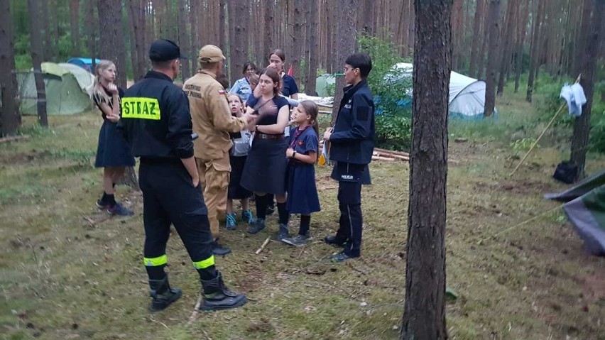 Policjanci i strażacy z wizytami w lesie. Odwiedzają obozy harcerskie 