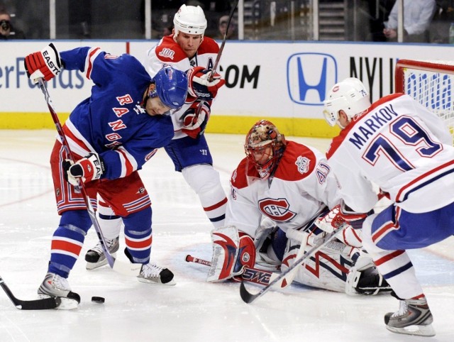 Mike Komisarek (2 L), Jaroslav Halak (2nd R) and Andrei Markov (P) z Montreal Canadiens i Rangers Nigel Dawes (L).