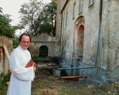 Proboszcz Wiesław Martuszewski pokazuje odkryte najstarsze mury świątyni.