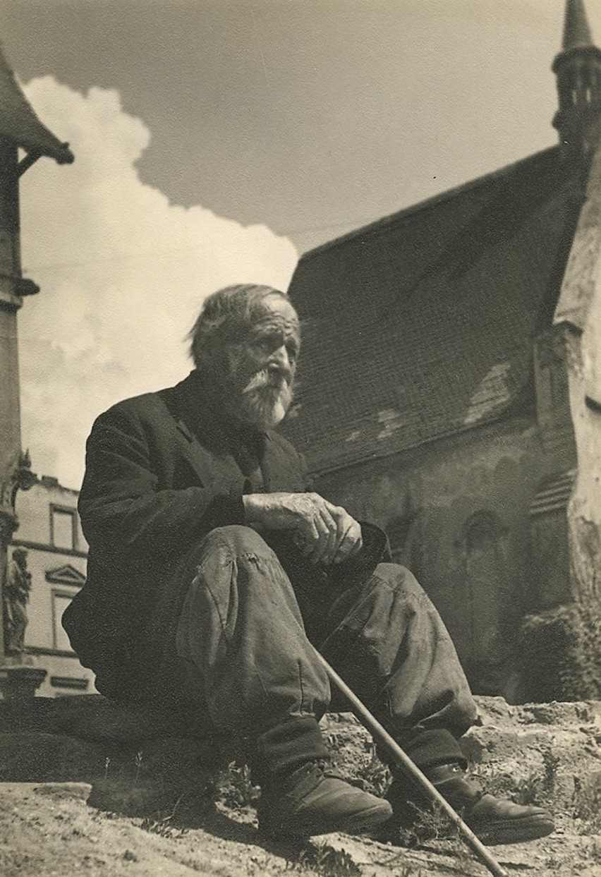 "Staruszek" - fotografia mężczyzny siedzącego na gruzach...