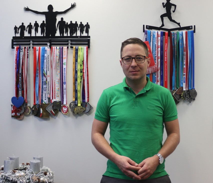 Tomasz Dzionek, a za nim, zdobyte na wielu biegach, pamiątkowe medale