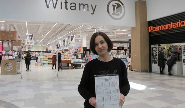 Agnieszka Witczak - Armacińska z hipermarketu E.Leclerc prezentuje kalendarz niedziel wolnych od handlu, który mogą zobaczyć klienci sklepu.