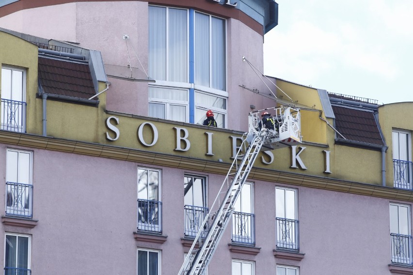 Akcja ratunkowa pod hotelem Radisson Blu Sobieski. Po gzymsie budynku chodzi człowiek 