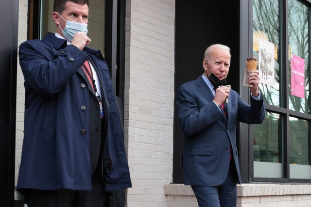 Prezydent USA Joe Biden pozdrawia obywateli trzymając w dłoniach lody w rożku. Wychodził z lodziarni Jeni's Ice Cream w Waszyngtonie 25 stycznia 2022 roku.