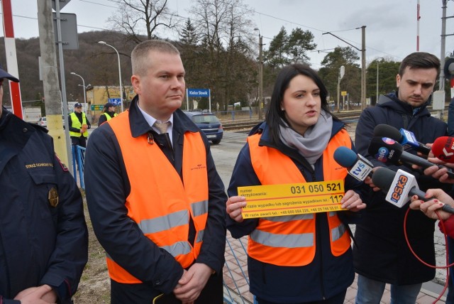 Izabela Miernikiewicz z Biura Prasowego PKP Polskie Linie Kolejowe pokazuję nalepkę, która zawiera numery potrzebne do wezwania pomocy, jeśli wydarzy się coś niespodziewanego na przejeździe kolejowym.