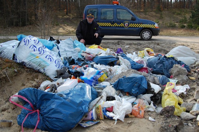 Krzysztof Kuc przy stercie śmieci niedaleko oczyszczalni ścieków
