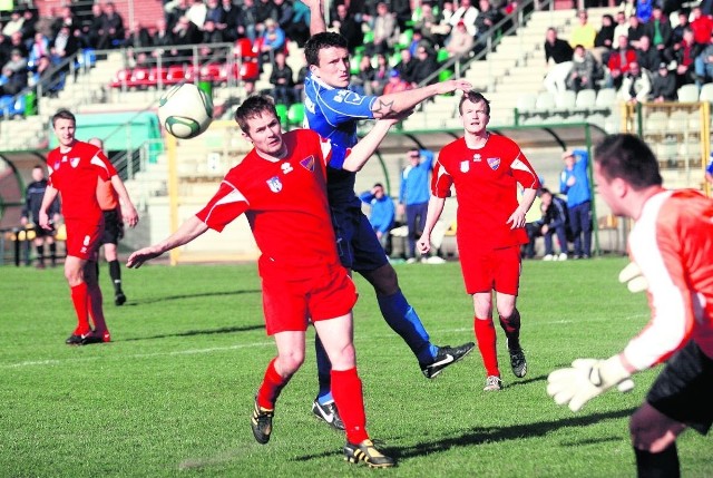 Napastnik Miedzi Legnica Jakub Grzegorzewski w powietrznej wlace z obrońcą Rakowa