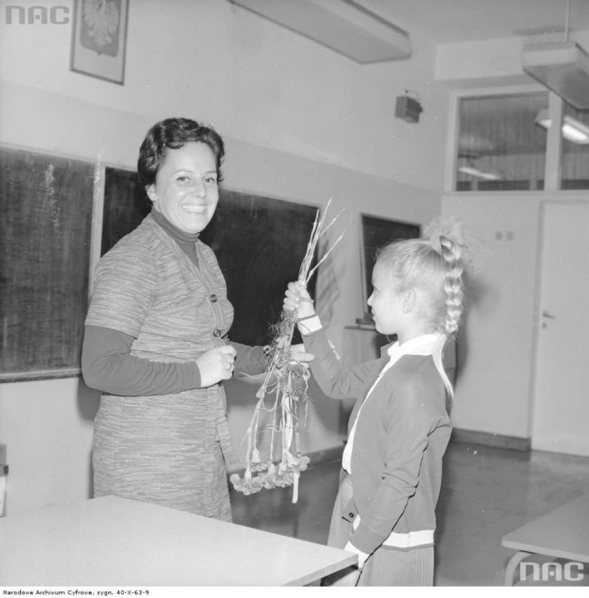 Uczennica wręcza kwiaty nauczycielce z okazji rozpoczęcia roku szkolnego, 1977-08-22.