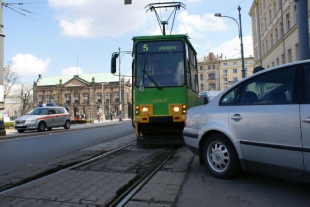 Tramwaje linii 28 czekają, aż laweta zabierze samochód.