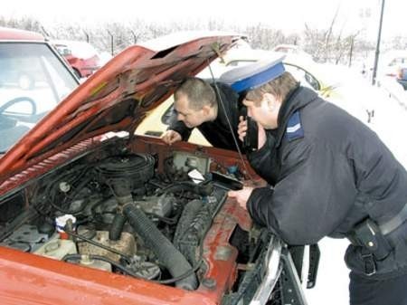 Starszy sierżant Mariusz Ziarko i sierżant sztabowy Maciej Maj sprawdzają numery silnika podczas kontroli samochodu.