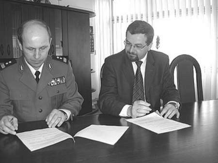 Mieczysław Skowron, komendant KPP, i prezydentRadosław Baran podpisują porozumienie, dzięki któremu komenda wzbogaci się o nowy samochód.