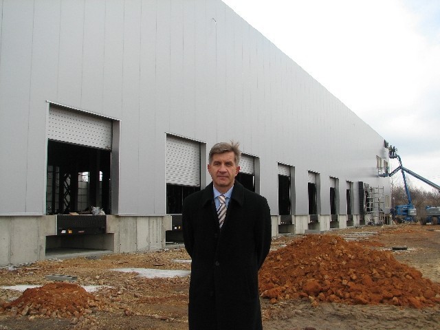 Roman Sobczyk przed powstającą w Sokpolu halą wysokiego składowania z 10 terminalami