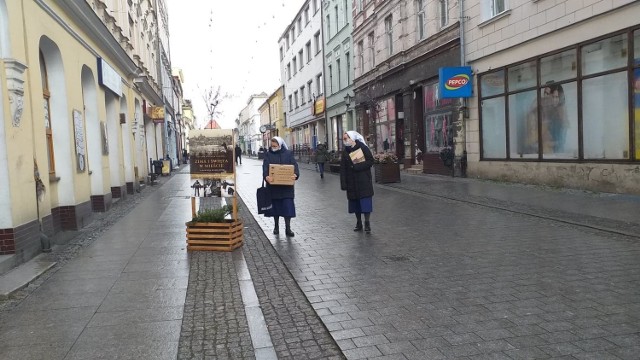 Wystawa zdjęć mieszkańców sprzed lat, zainstalowana na ul. Grudziądzkiej w Chełmnie, od razu zaciekawiła przechodniów. Podobnie jak duża choinka przed ratuszem