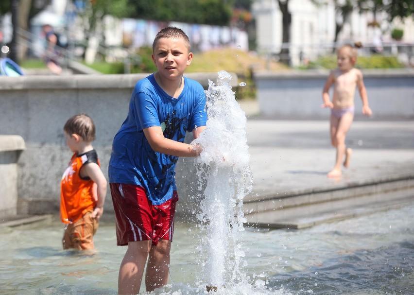Najmłodsi próbują ochłodzić się w fontannie w parku na...