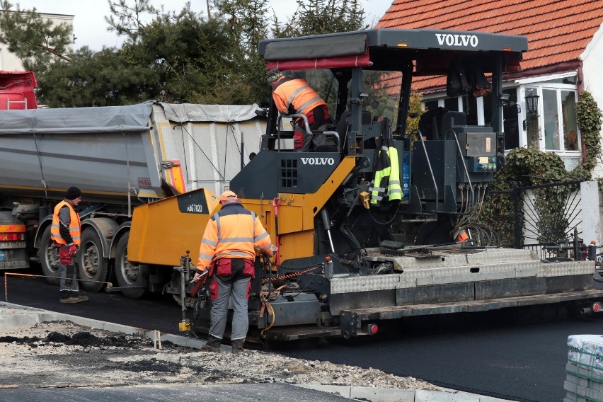 Wylewanie asfaltu na jezdni i ścieżce rowerowej ulicy...