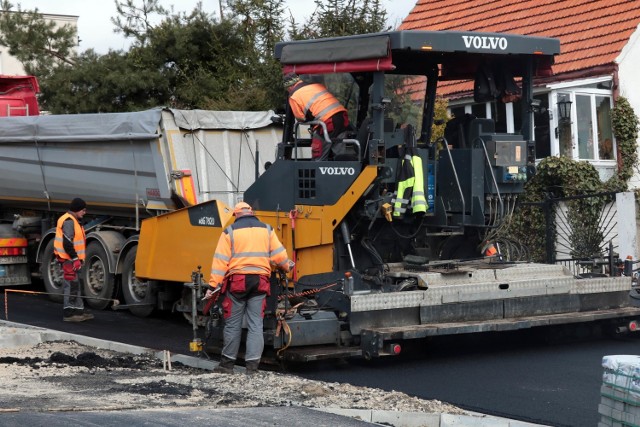 Wylewanie asfaltu na jezdni i ścieżce rowerowej ulicy Jackowskiego w Grudziądzu.