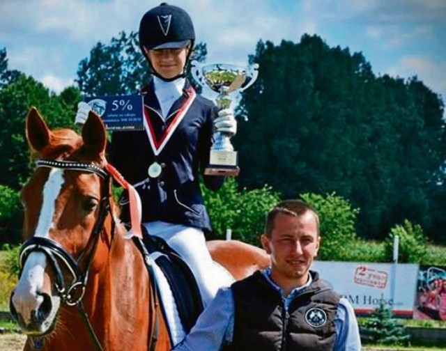Utalentowana Maja na koniu Mili prezentuje wywalczone trofeum. Towarzyszy jej trener Rafał Perlikowski.