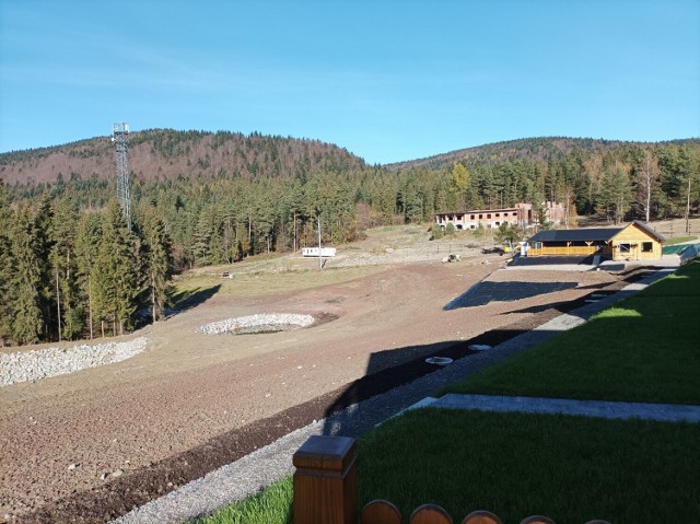 Widok spod domku letniskowego. Po lewej staw (jeszcze bez wody), w oddali niedokończona budowa, pod nią będzie wybieg dla alpak, bliżej - budynek knajpy.