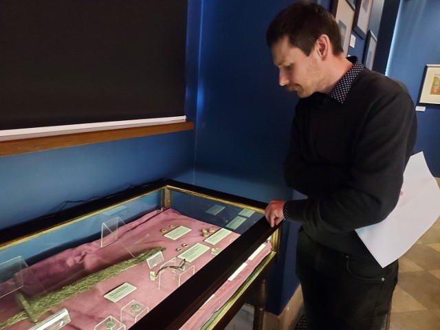 Na zdjęciu dr Wojciech Rajpold – adiunkt w dziale archeologii Muzeum Zamkowego, członek zespołu kuratorskiego przy eksponatach.