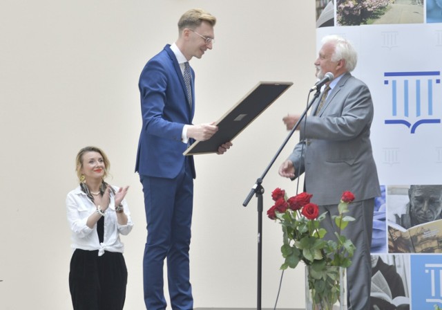 Życzenia dla biblioteki składa na ręce jej dyrektora, Przemysława Czai, Leszek Jastrzębiowski, prezes Radomskiego Towarzystwa Fotograficznego.