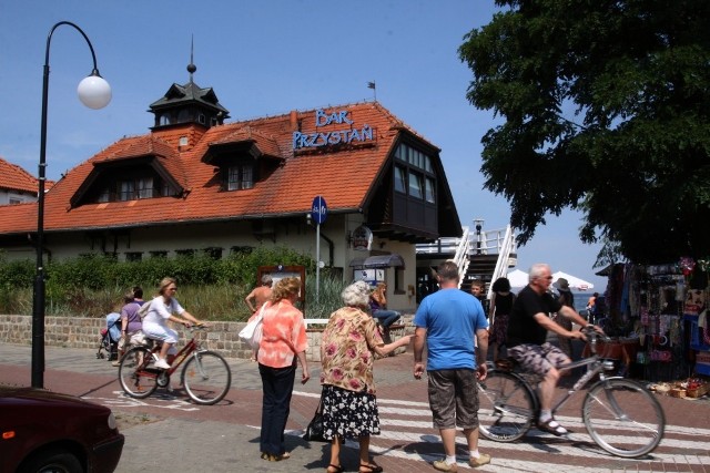 Sopot Bar Przystań

Dostać tu wolny stolik w weekend graniczy z cudem. I tak już od blisko 20 lat! Szczególnie upodobała sobie lokal warszawska elita: aktorzy, reżyserzy, ekipy telewizyjne, wreszcie politycy. Któregoś dnia, wiele lat temu, "śledzika" urządzała tu ekipa teatru Kwadrat z Warszawy. Po "wiejskim śledziu" zjedli Janek Kobuszewski, Jan Kociniak, Paweł Wawrzecki.  Przyszli prawie koło północy, więc dzwonili wcześniej, błagali: Jeszcze nie zamykajcie! Poczekajcie na nas! Czekali. Ale przecież, jak napisali o barze goszczący tu wiosną Piotr Machalica, Jerzy Zelnik, Katarzyna Skrzynecka: Uwaga!!! Nie wyrzucają o 23!!! 

Byli tu i wpisali się: Kult z Kazikiem Staszewskim na czele (po rosyjsku), Jan Nowicki, gdy na molu kręcono zdjęcia do "Sztosa", zresztą ekipa reżysera Olafa Lubaszenki spotykała się tu co wieczór. Nikt już dziś nie pamięta, czy zajadali się rekinem czy zwykłą flądrą. Była Kasia Kowalska z zespołem, przy jednym stoliku pod oknem siadywali Halina Frąckowiak z Ryszardem Rynkowskim, Andrzej Rosiewicz pijał piwo na tarasie latem i pisał: "Barze! Płyń przez morza i oceany!".
Na rybę w cieście wpadali tu z sopockiego festiwalu Alicja Majewska i Włodzimierz Korcz.
-&nbsp;Rybka lubi pływać! - mawiali stali bywalcy z Budki Suflera. Prosto z koncertów pędzili w to miejsce Proletariat i T.Love. Jadał tu dorsze na tarasie Daniel Olbrychski z żoną i Januszem Morgensternem. A Grzegorz Markowski wpisał się w pamiątkowej księdze: "Było Perfect, Perfect, Perfect...".

Wybierz najlepszą restaurację w Sopocie. Weź udział w naszym plebiscycie