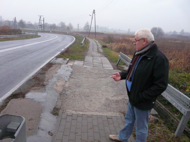 Grzegorz Michalski pokazuje zniszczony chodnik przy DK 42