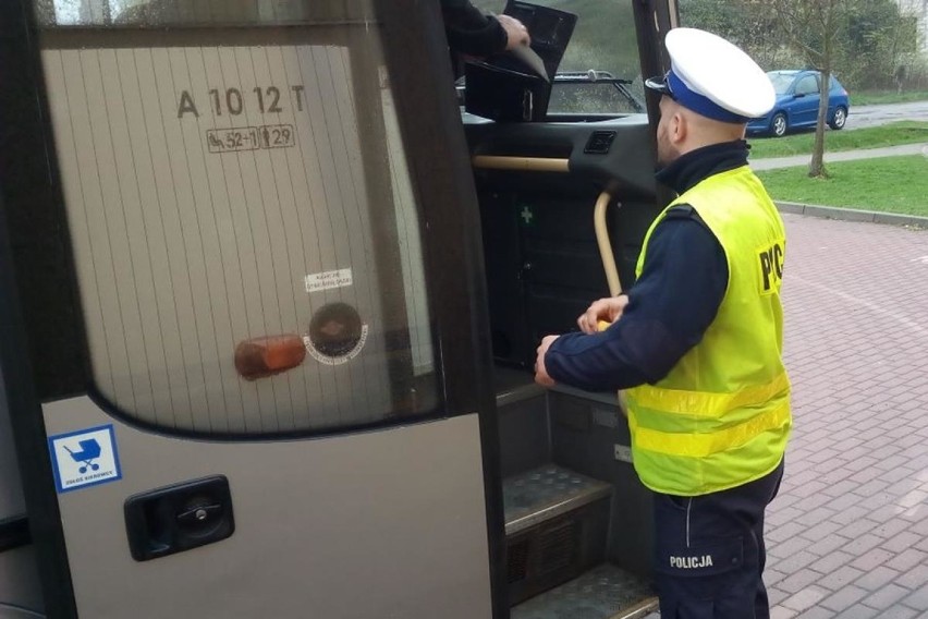 Policjanci kontrolują autokary przed wyjazdem.