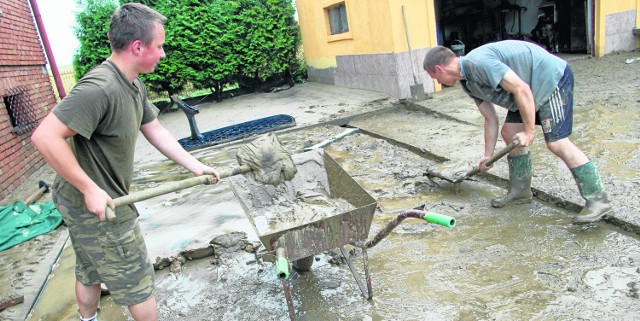21-letni Michał Brożek z Zastowa wraz z 18-letnim bratem Tomkiem usuwają szlam z podwórka. W niedzielę zalało ich drugi raz w ciągu miesiąca