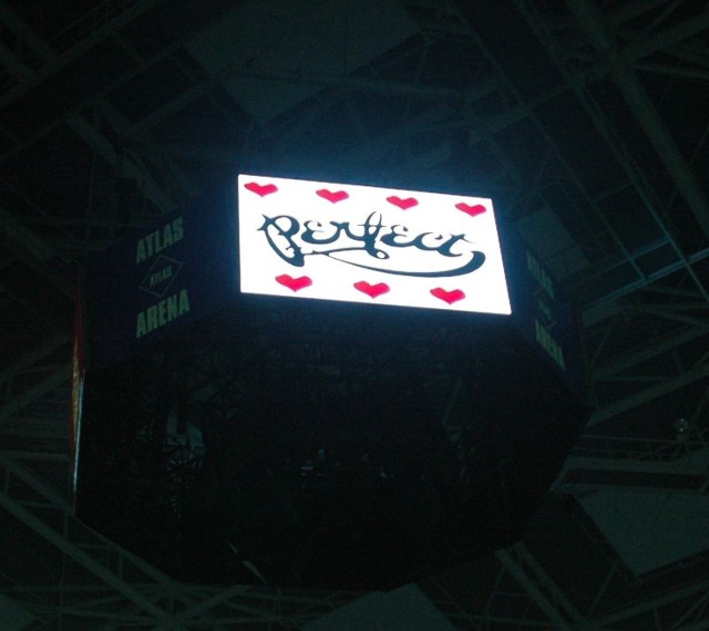 Nad głowami publiczności, na ekranie widniała nazwa zespołu w otoczeniu serc. Fot. Piotr Drzewiecki