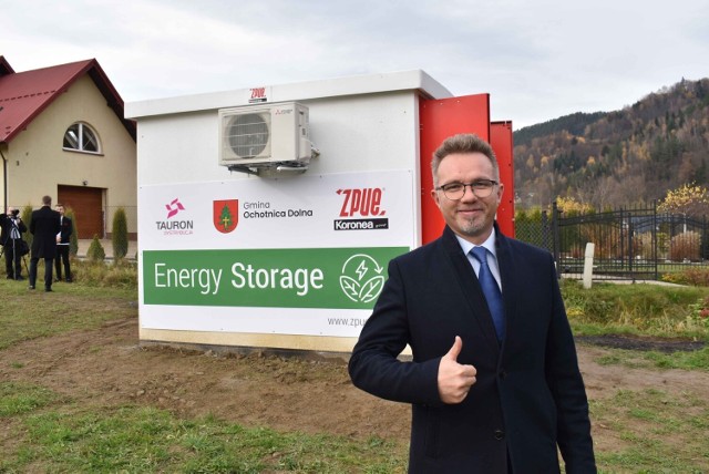 Tadeusz Królczyk - wójt gminy Ochotnica Dolna a w tle nowy magazyn energii. Dzięki niemu instalacje fotowoltaiczne, które zainstalowali ludzie na swoich domach nie będą się wyłączały w środku słonecznego dnia