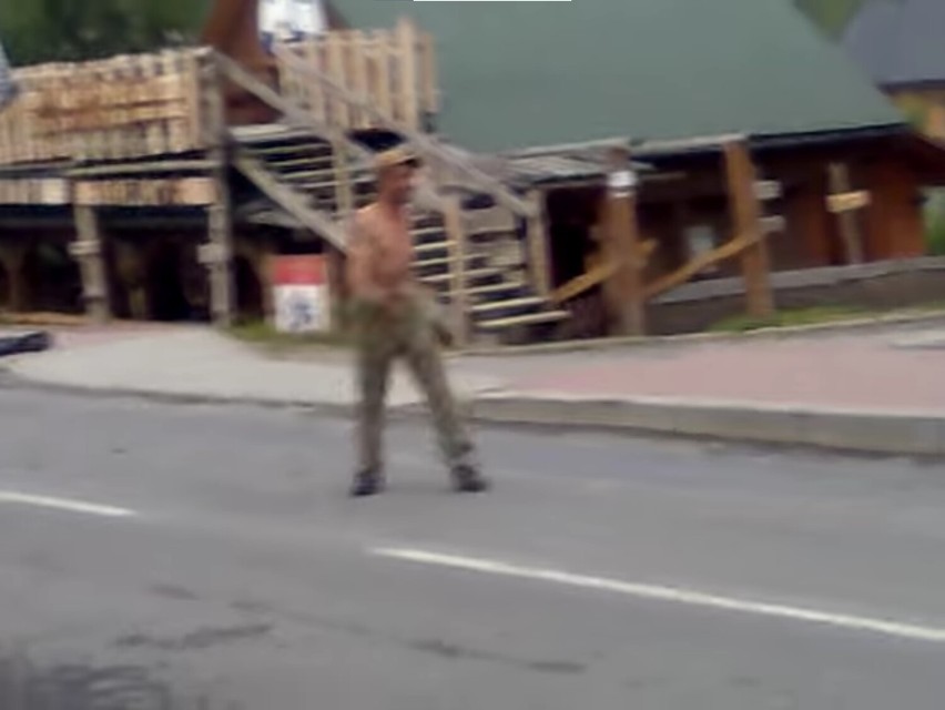 Tańczący na środku drogi mężczyzna bez koszulki. Tak w...
