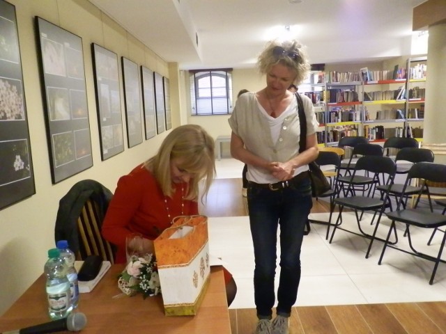 Katarzyna Sarnowska podpisuje książkę w filii nr 11.