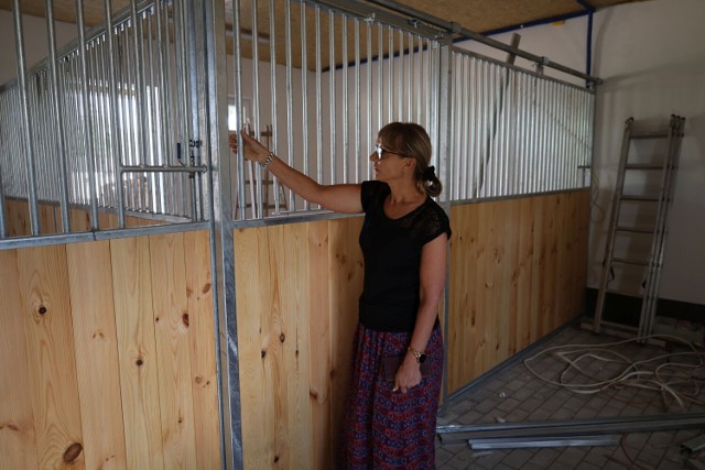 Dyrektor ZS nr 6 Joanna Buzała pokazuje boksy dla zwierząt w nowym budynku inwentarskim