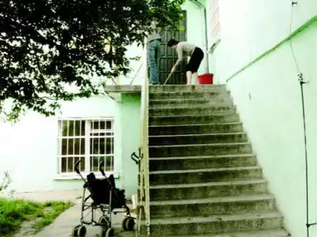 Wczoraj przed południem mieszkańcy Domu Samotnej Matki w Wiktorowie zmywali ze schodów krew, jaka pozostała po nocnej awanturze - Fot. ANDRZEJ SZOZDA