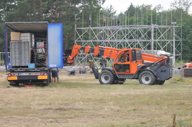 Do rozpoczęcia Przystanku Woodstock 2017 zostały 23 dni. W Kostrzynie nad odrą ruszyła już budowa Dużej Sceny Przystanku Woodstock 2017. Co chwila na woodstockową łąką przyjeżdżają kolejne ciężarówki, po brzegi wyładowane elementami festiwalowej infrastruktury. 



Na łące w Kostrzynie nad Odrą zaczyna powstawać ogromne miasto. W poniedziałek, 10 lipca, ruszyła budowa Dużej Sceny Przystanku Woodstock 2017. We wtorek konstrukcja sceny miała już kilka metrów wysokości. Monterzy sprawnie dokładają kolejne elementy, z których powstaje metalowy szkielet. Do Kostrzyna przyjechały też już pierwsze kontenery, w  których będzie zaplecze Przystanku Woodstock 2017.

Na terenie woodstockowej łąki pracują też fachowcy z Miejskich Zakładów Komunalnych. Podłączają wodę w miejscach, gdzie będą zlewy i stoiska gastronomiczne. Wykoszona została łąka przed sceną i w miejscu, gdzie staną krany. Na woodstockowej łące pracują też elektrycy, którzy podprowadzają prąd do stojących na polu lamp. Trwa również budowa woodstockowego marketu.

Wioska pierwszych woodstockowiczów się rozrasta. To Świrusa, Czekolady i Kapłana dołączył Tomek. - Przyjechałem z Warszawy do pracy. Tak jak rok temu będę pracował przy rozstawianiu płotów - mówi. Przy drodze, prowadzącej przez woodstockowe pole, coraz częściej zatrzymują się mieszkańcy Kostrzyna. Każdy obserwuje, jak w środku łąki rośnie wielkie, woodstockowe miasto.

Przystanek Woodstock 2017 rozpocznie się w czwartek, 3 sierpnia i potrwa do soboty, 5 sierpnia. Będzie to już 23. edycja festiwalu.