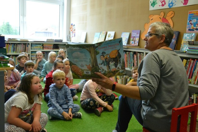 Dzieciom podczas spotkania w bibliotece w Wielgiem kolejną interesującą historię czyta dyrektorka Katarzyna Kwiecińska