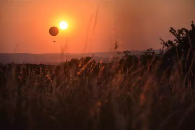 Najpiękniejsze panoramy w Małopolsce. Te miejsca warto odwiedzić. Na zdjęciu widok z Kopca Kraka podczas zachodu słońca z balonem.