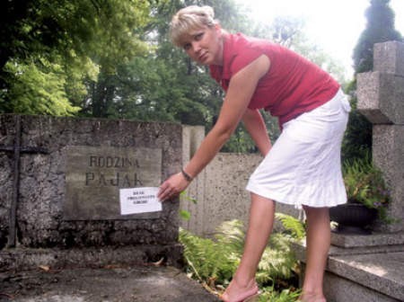Karina Żyłka, kierowniczka cieszyńskich cmentarzy komunalnych, pokazuje jeden z grobów, który nie został opłacony przez bliskich.