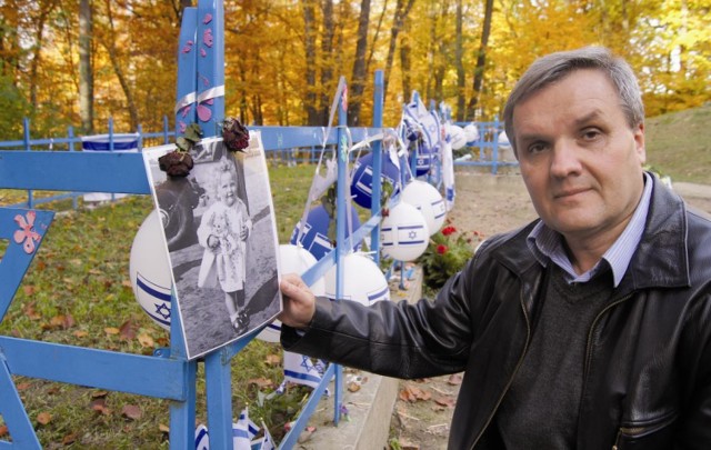 Adam Ryba przy kwaterze, w której pochowane są żydowskie dzieci. Znajdują się na niej m.in. zdjęcia, maskotki i baloniki