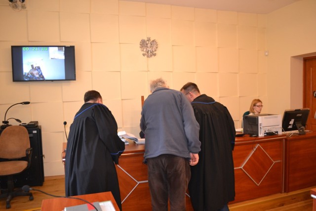 Świadek Jacek Nowak z Turu oraz reprezentujący strony mecenasi  przed stołem sędziowskim.
