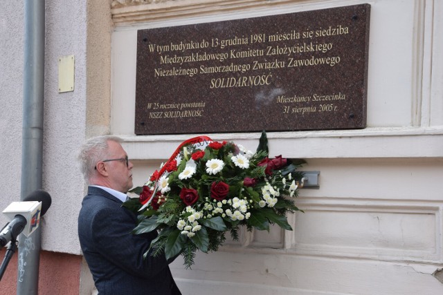 Cezary Jankowski składa kwiaty przy tablicy upamiętniającej dawnych związkowców ze Szczecinka