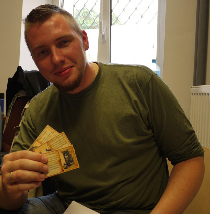 Jacek Gut, grafik, prezentuje karty do gry