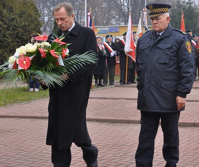 Kwiaty pod pomnikiem składają: prezydent Zamościa Marcin Zamoyski i szef Straży Miejskiej Wiesław Gramatyka